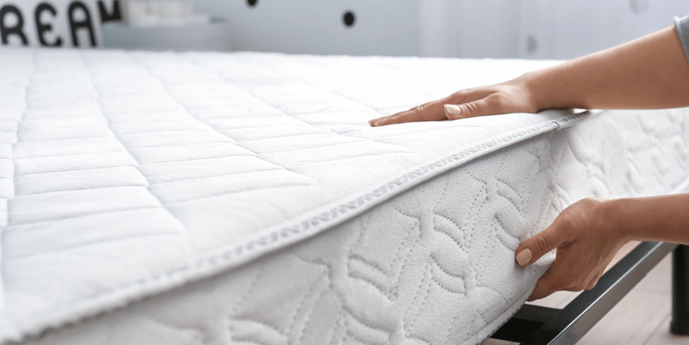 woman placing a memory foam mattress on a bed frame